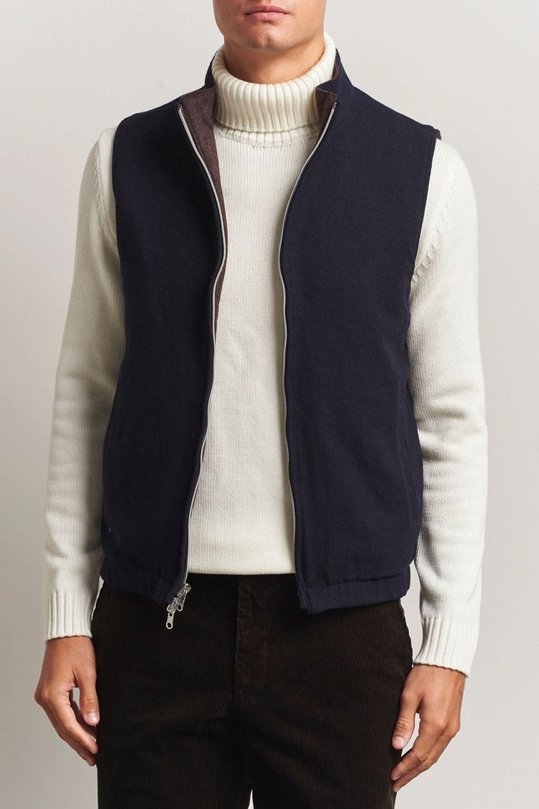 Homme portant un gilet en laine reversible Stenströms avec col roulé blanc, fermeture à double zip, et poches, idéal pour un look raffiné.