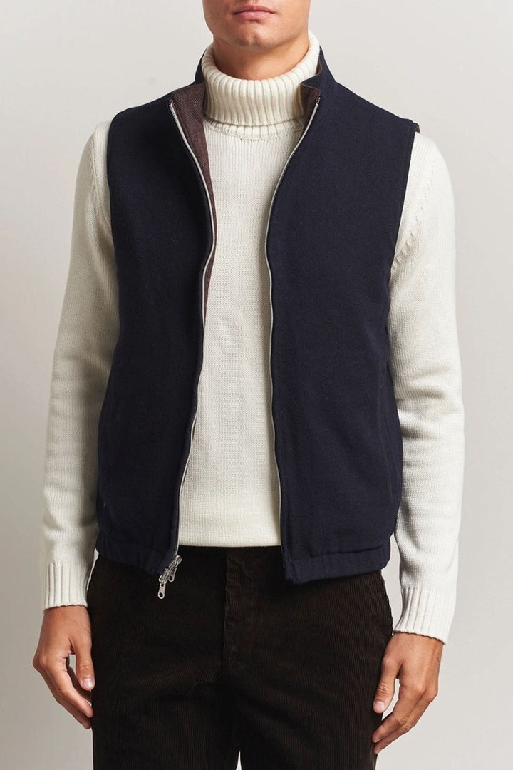 Homme portant un gilet en laine reversible Stenströms avec col roulé blanc, fermeture à double zip, et poches, idéal pour un look raffiné.