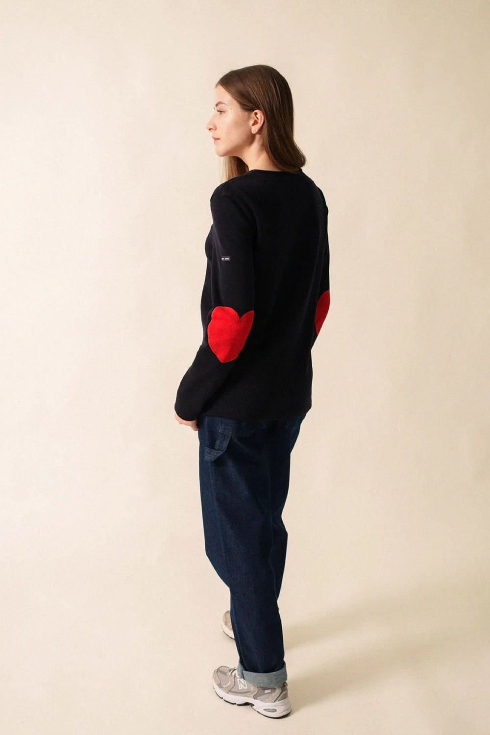 Chandail Vaujany à encolure ronde avec coudes en forme de cœur rouge, porté avec un jean droit.