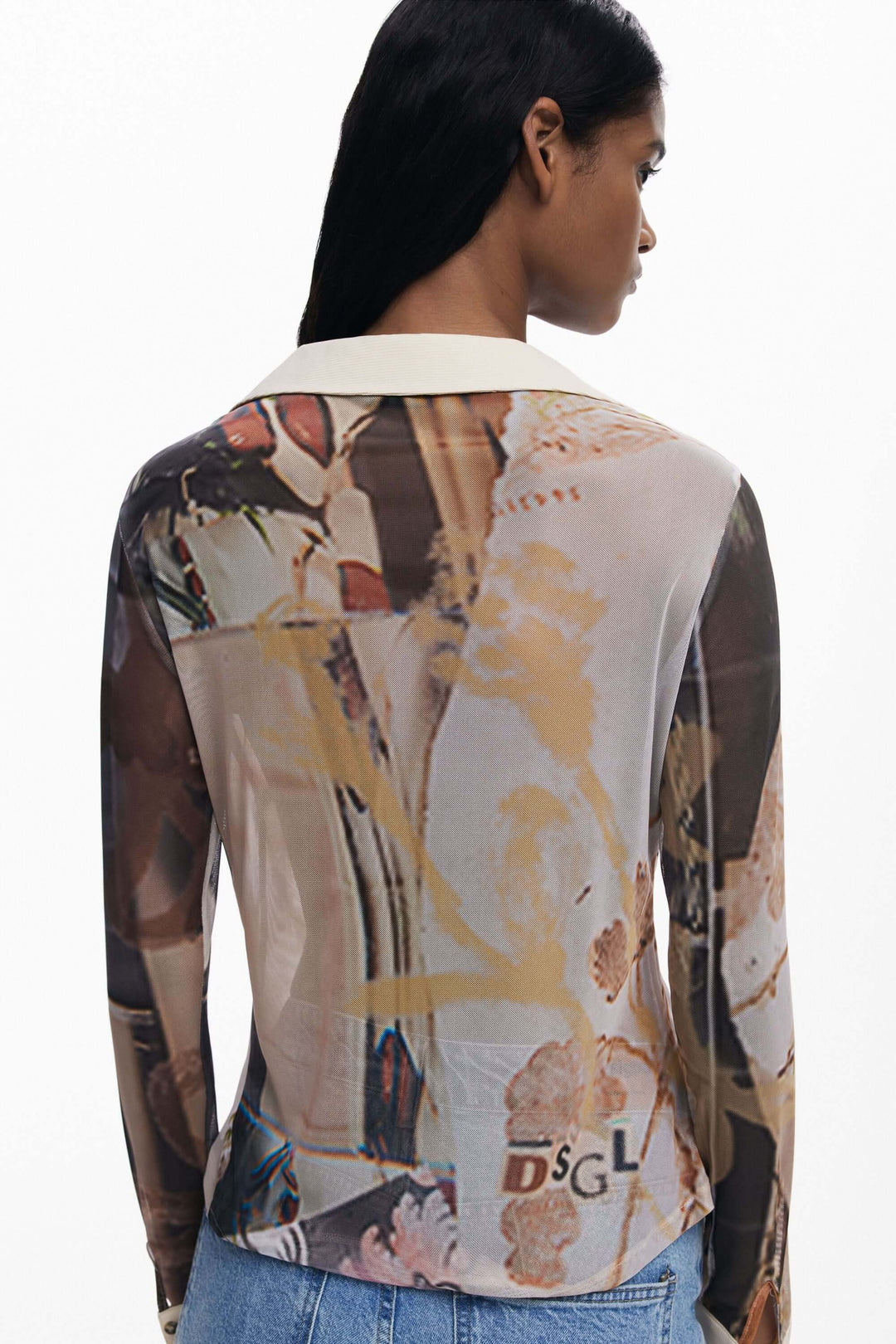 Femme portant un T-shirt en mousseline avec poignets, imprimé artistique, col contrasté, coupe ajustée, style graphique et élégant.