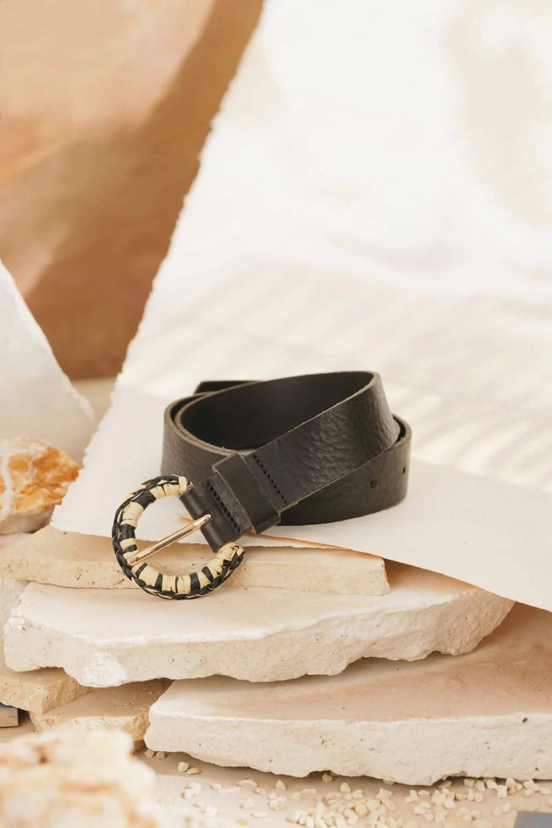 Ceinture Malvina en cuir noir avec boucle en raphia, parfaite pour accessoiriser robes ou shorts.