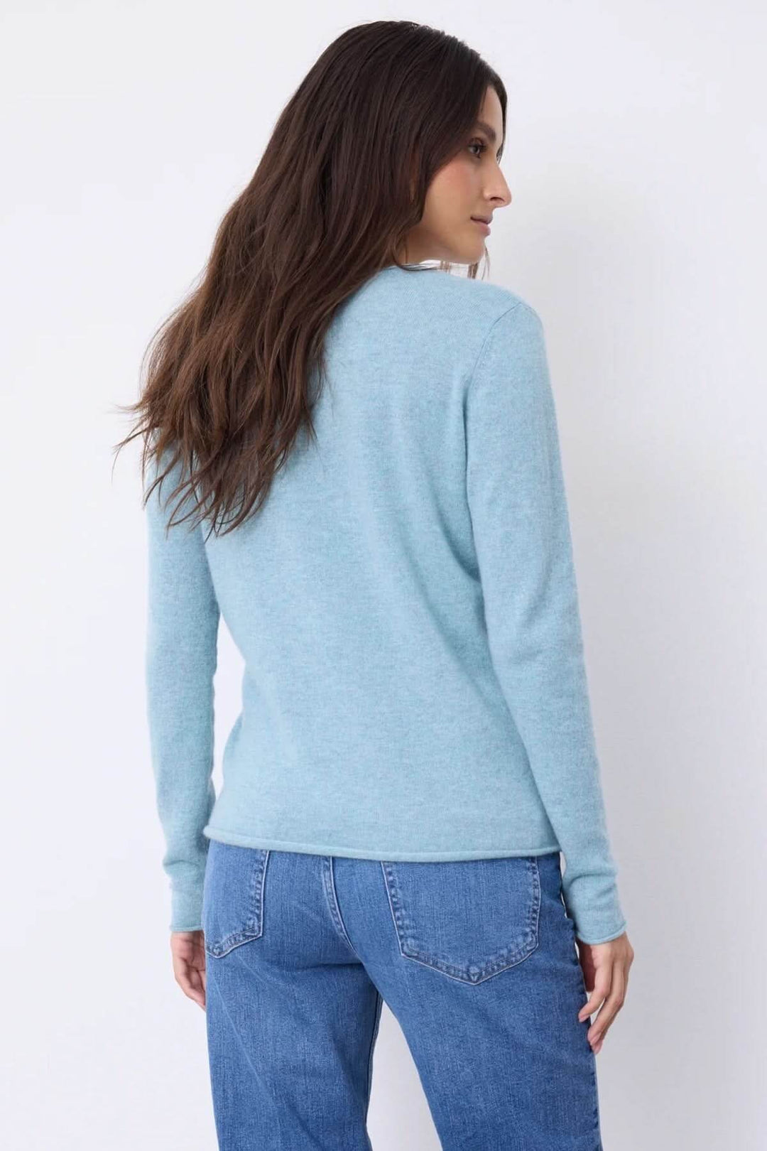 Chandail à manches longues en bleu avec encolure en V, porté avec un jean pour un look décontracté.