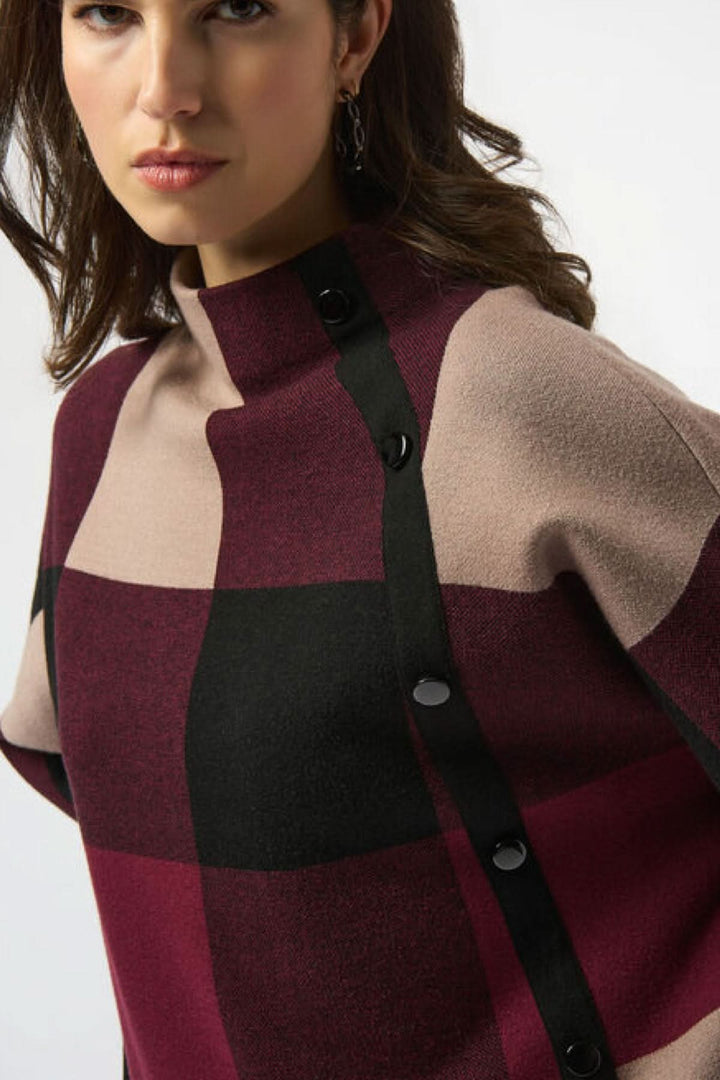 Chandail à col montant avec motif carreauté en tons bordeaux et beige, boutons décoratifs sur le côté.