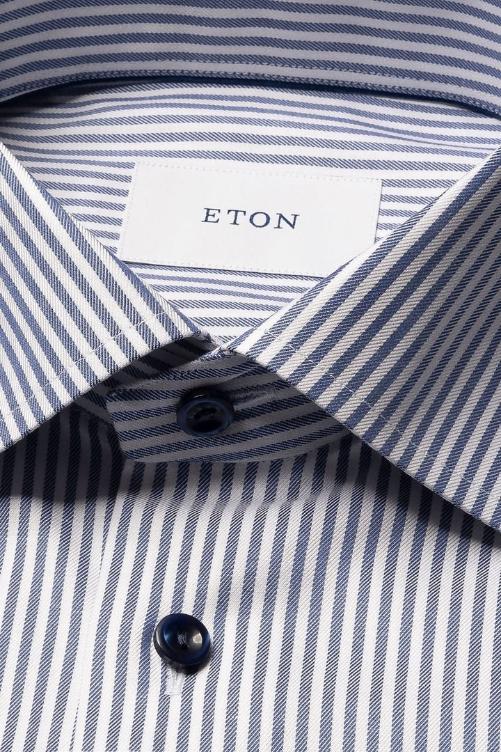 Chemise lignée élégante et intemporelle avec rayures bleues et col cutaway, idéale pour un look sophistiqué et confortable.