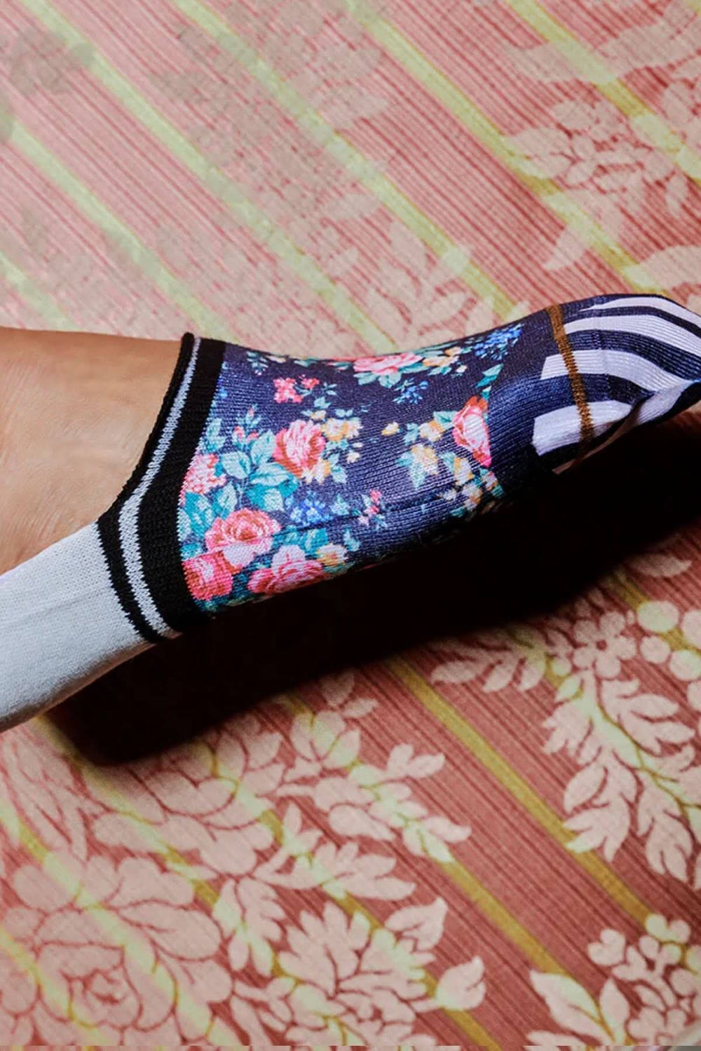 Chaussettes basses Nikki avec imprimé floral sur fond sombre et rayures, parfaites pour un style décontracté.