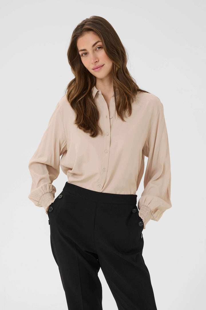 Woman wearing Blouse Nola fluide à poignets smockés with elegant and relaxed fit.