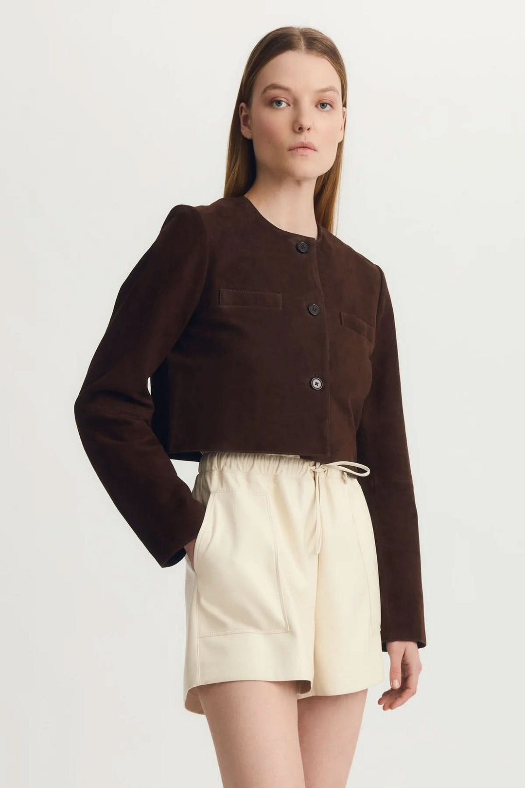 Veste Glenda en suède marron, chic et moderne avec fermeture à boutons, portée par un mannequin élégant.