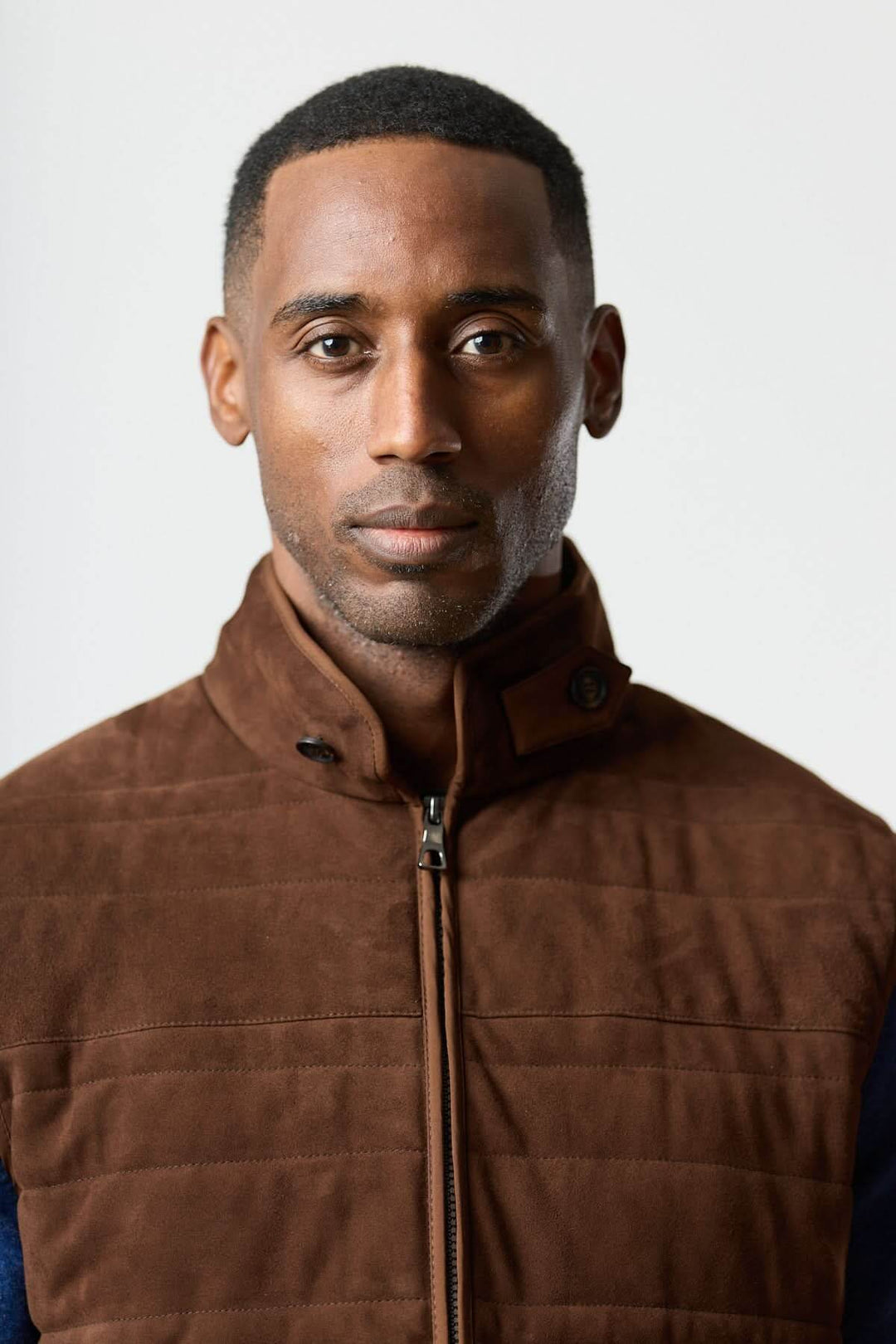 Veste sans manches en simili suède, offrant une allure raffinée, matelassage léger et tissu contrastant, adaptée pour chandails ou chemises.