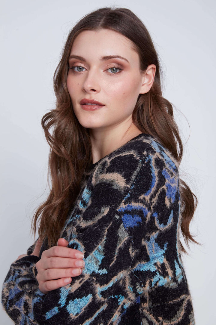 Tricot à manches longues avec motif abstrait coloré, offrant confort et style moderne.