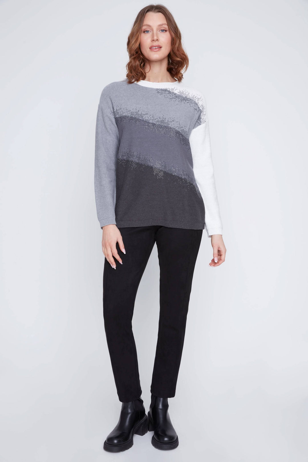Chandail à dégradés gris avec détails scintillants, coupe droite et confortable, porté avec un pantalon noir.