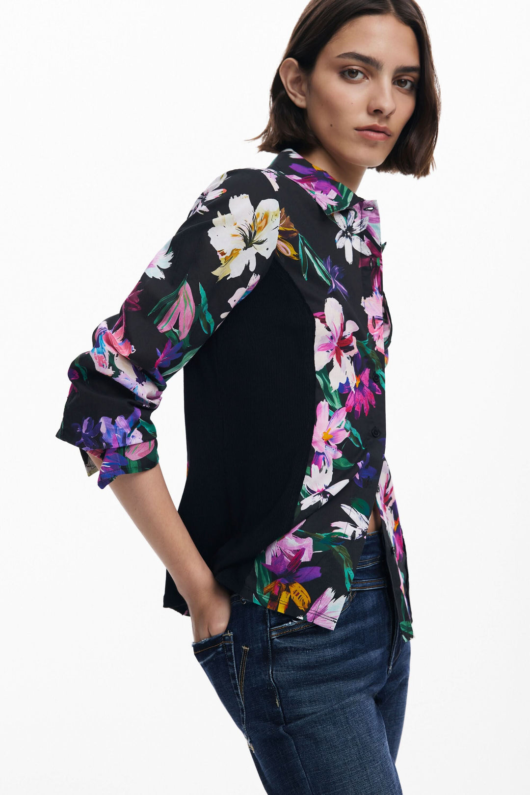 Chemise à fleurs avec coupe ajustée, fond noir et manches longues, portée avec un jean.