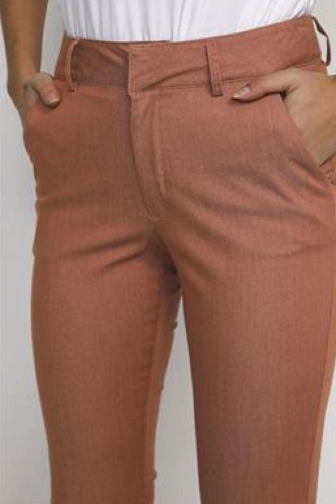 Pantalon chino en couleur terre cuite, idéal pour l'été, s'associe bien avec un haut blanc.