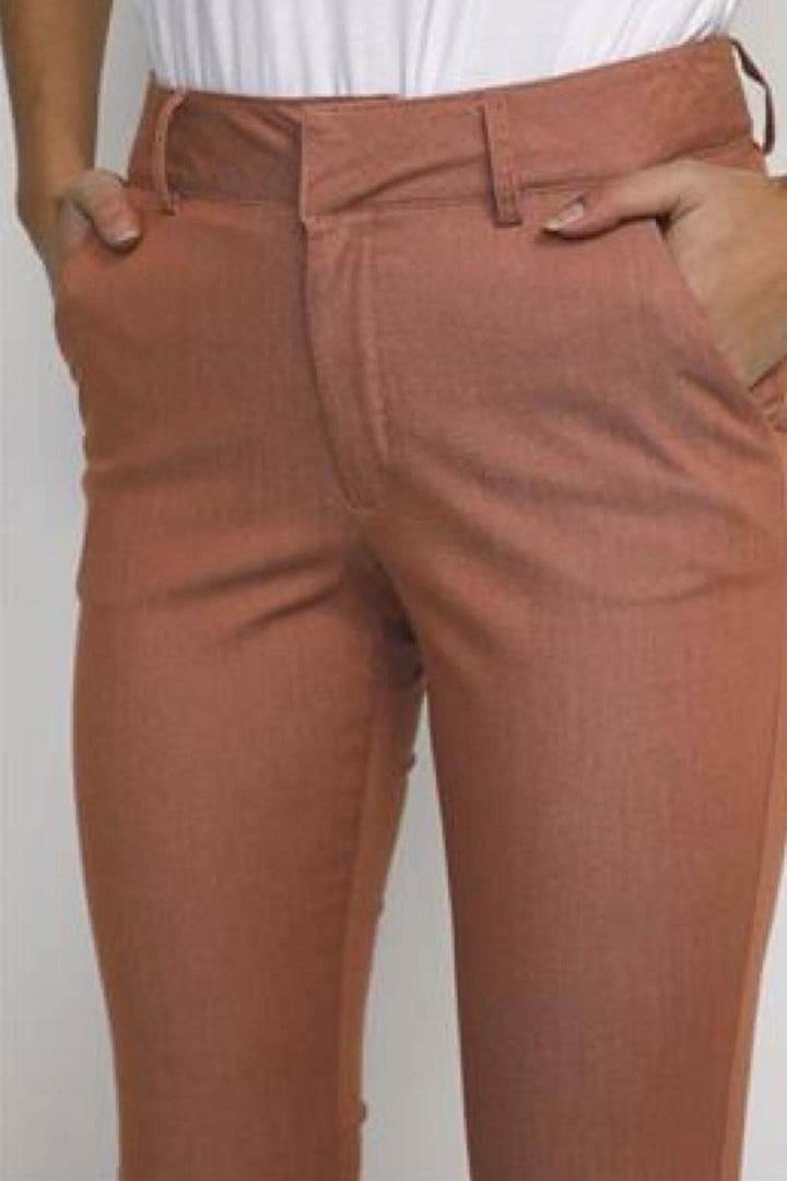 Pantalon chino en couleur terre cuite, idéal pour l'été, s'associe bien avec un haut blanc.