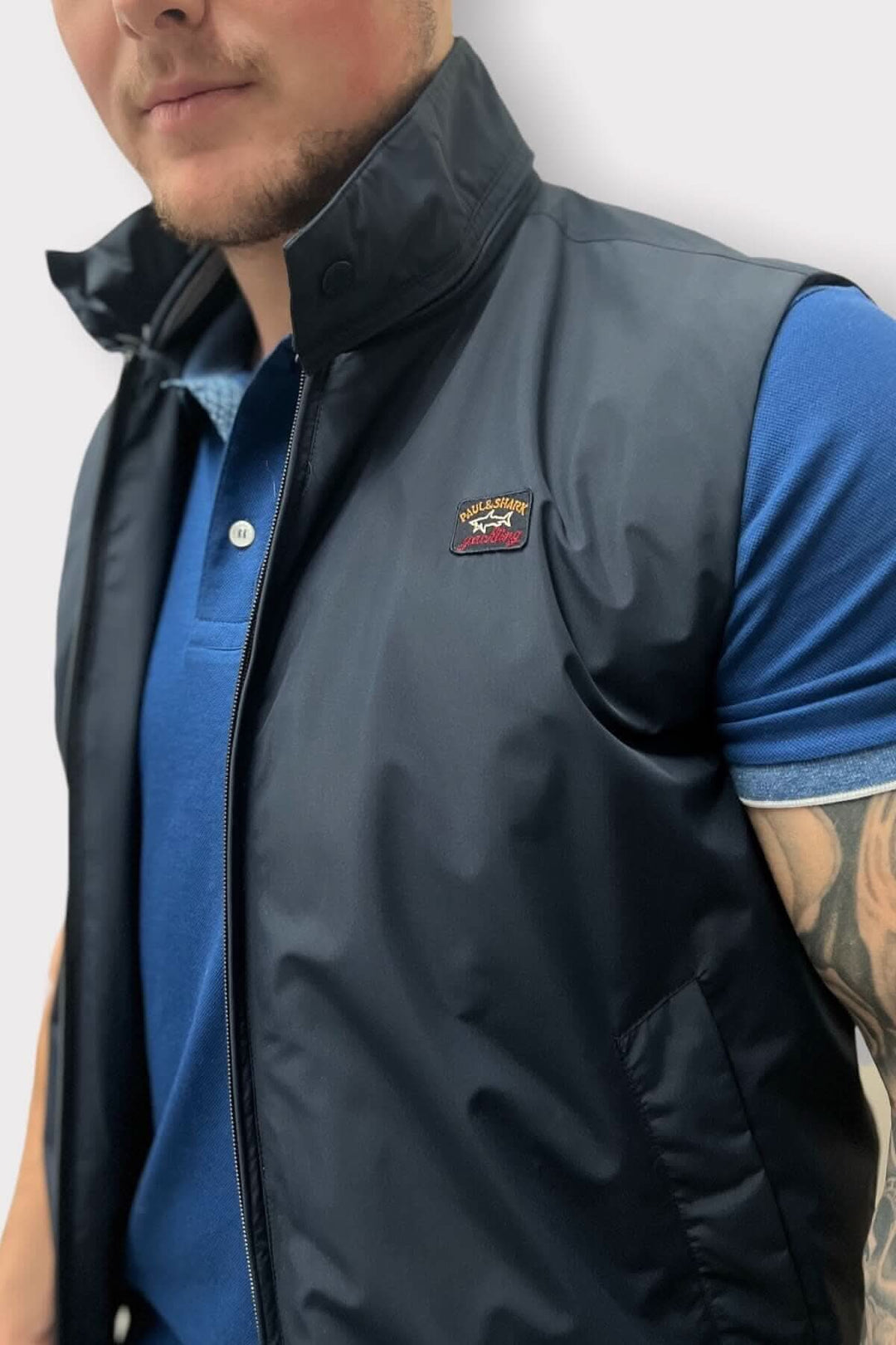 Veste sans manches en nylon, collet détaillé, portée par un mannequin, style décontracté.