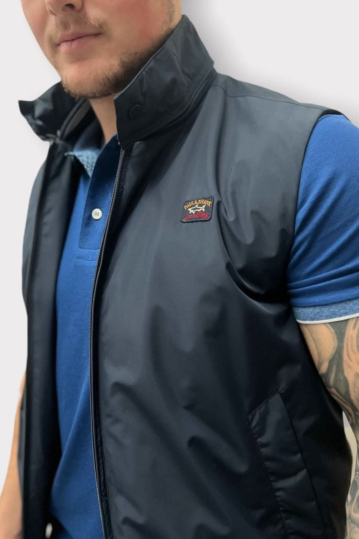 Veste sans manches en nylon, collet détaillé, portée par un mannequin, style décontracté.