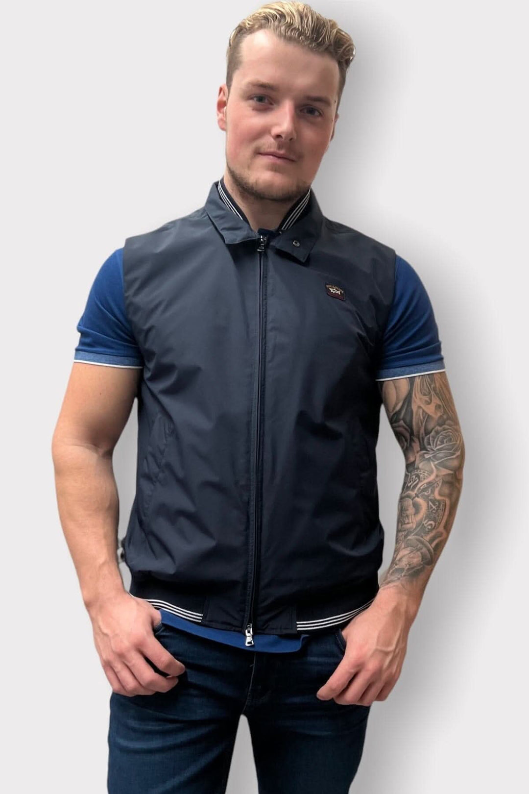 Homme portant une veste sans manche en nylon, détails au collet, coupe régulière, fait en Italie.