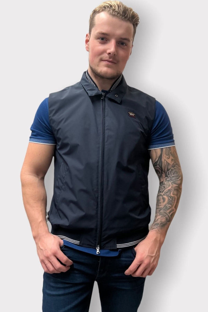 Homme portant une veste sans manche en nylon, détails au collet, coupe régulière, fait en Italie.