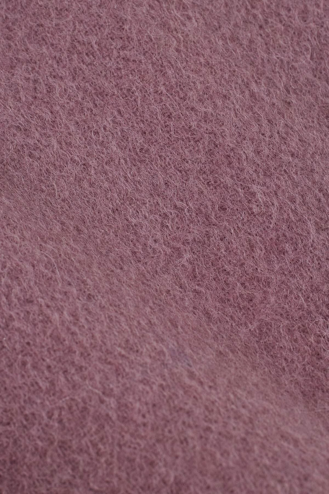 Zoom sur le tissu doux en laine du foulard Anna, couleur rose chaud et texturé.