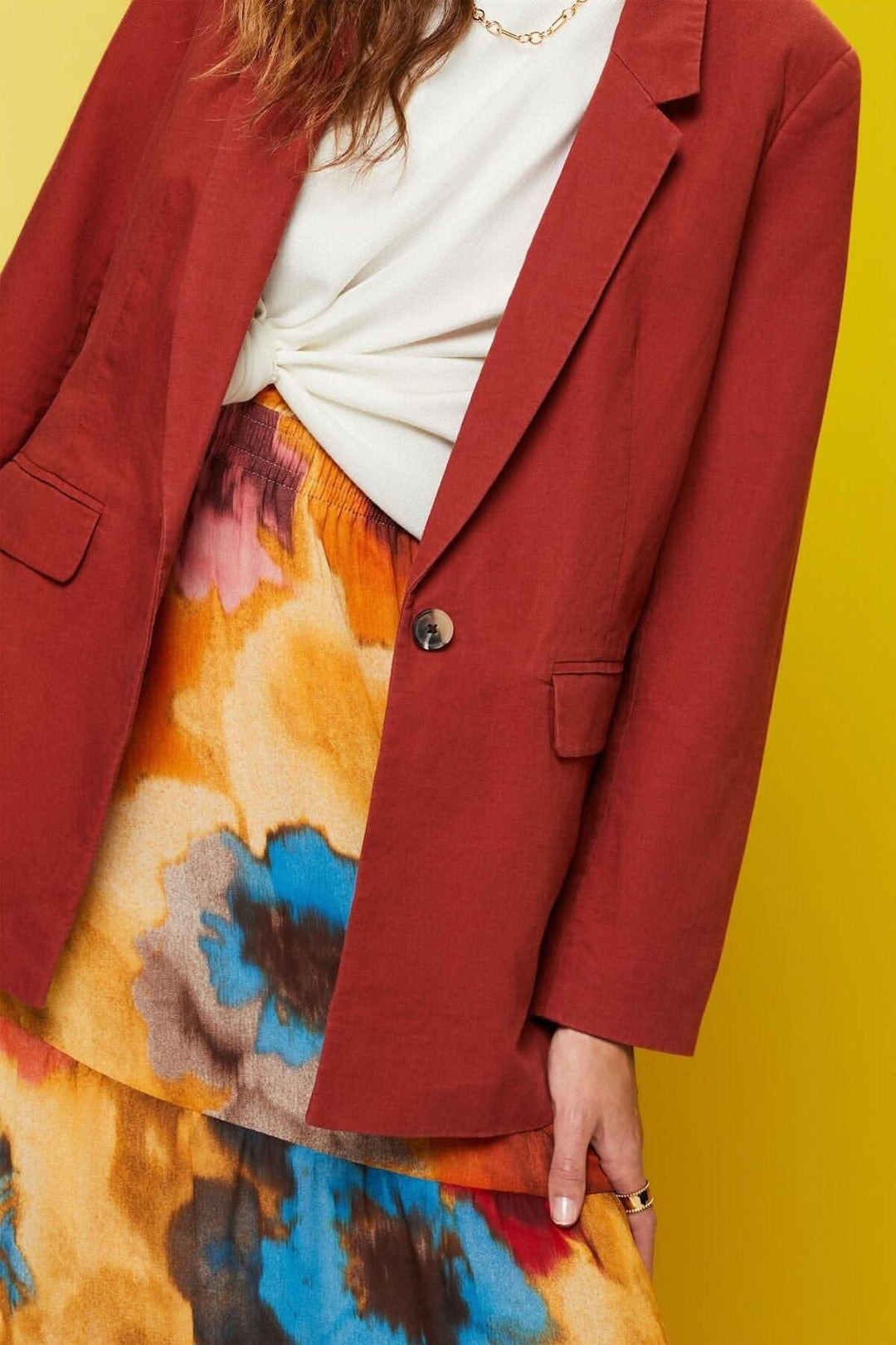 Blazer à simple boutonnage en lin avec une jupe colorée, look chic et tendance.