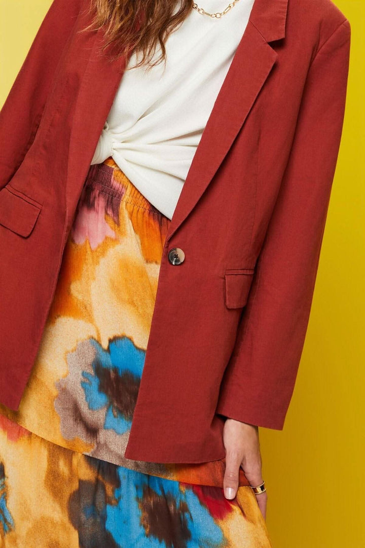 Blazer à simple boutonnage en lin avec une jupe colorée, look chic et tendance.