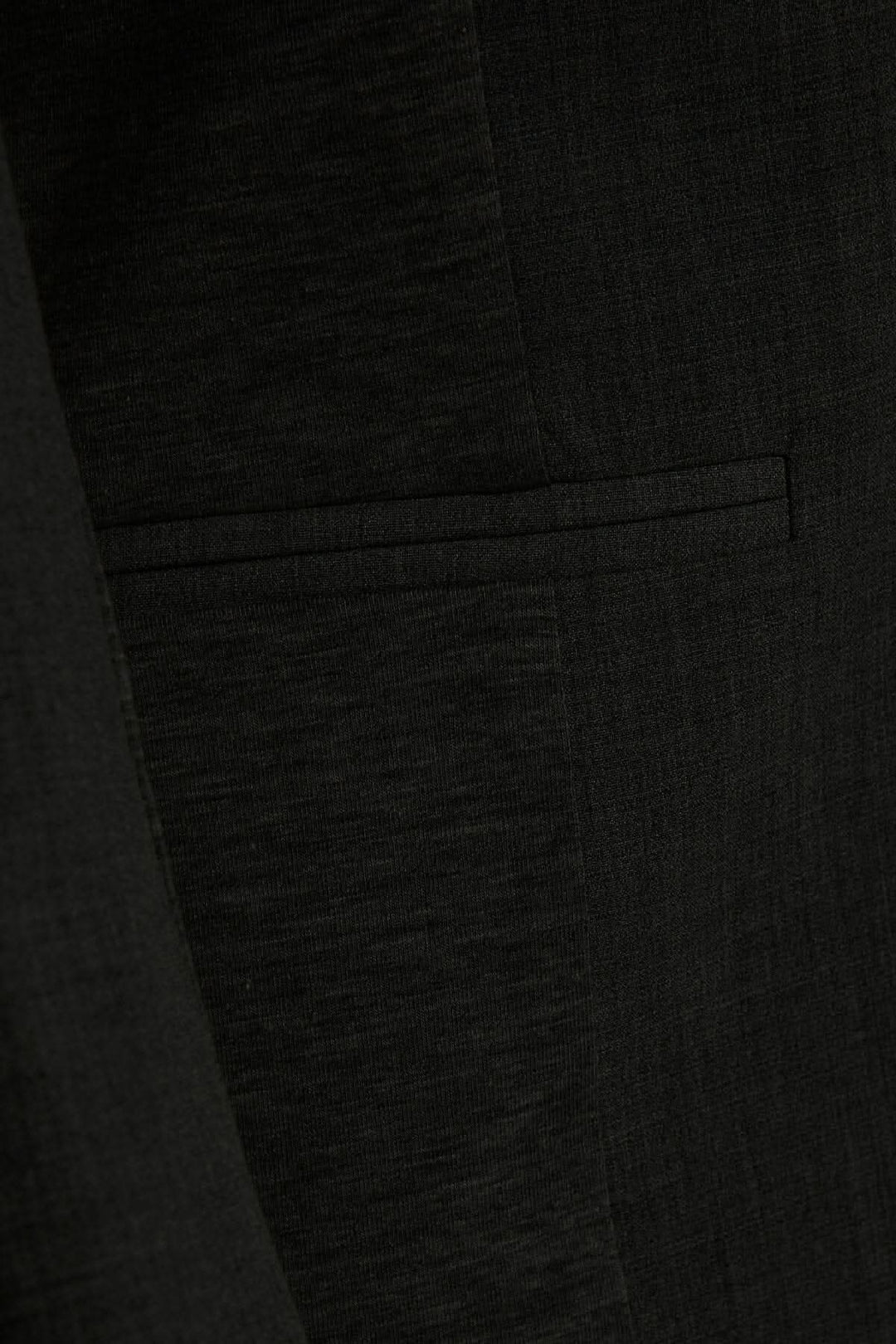 Détail du veston Kajillian montrant la texture et la poche avant.