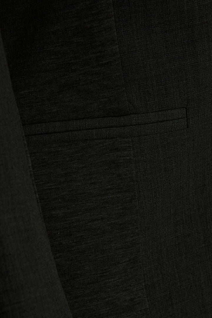 Détail du veston Kajillian montrant la texture et la poche avant.