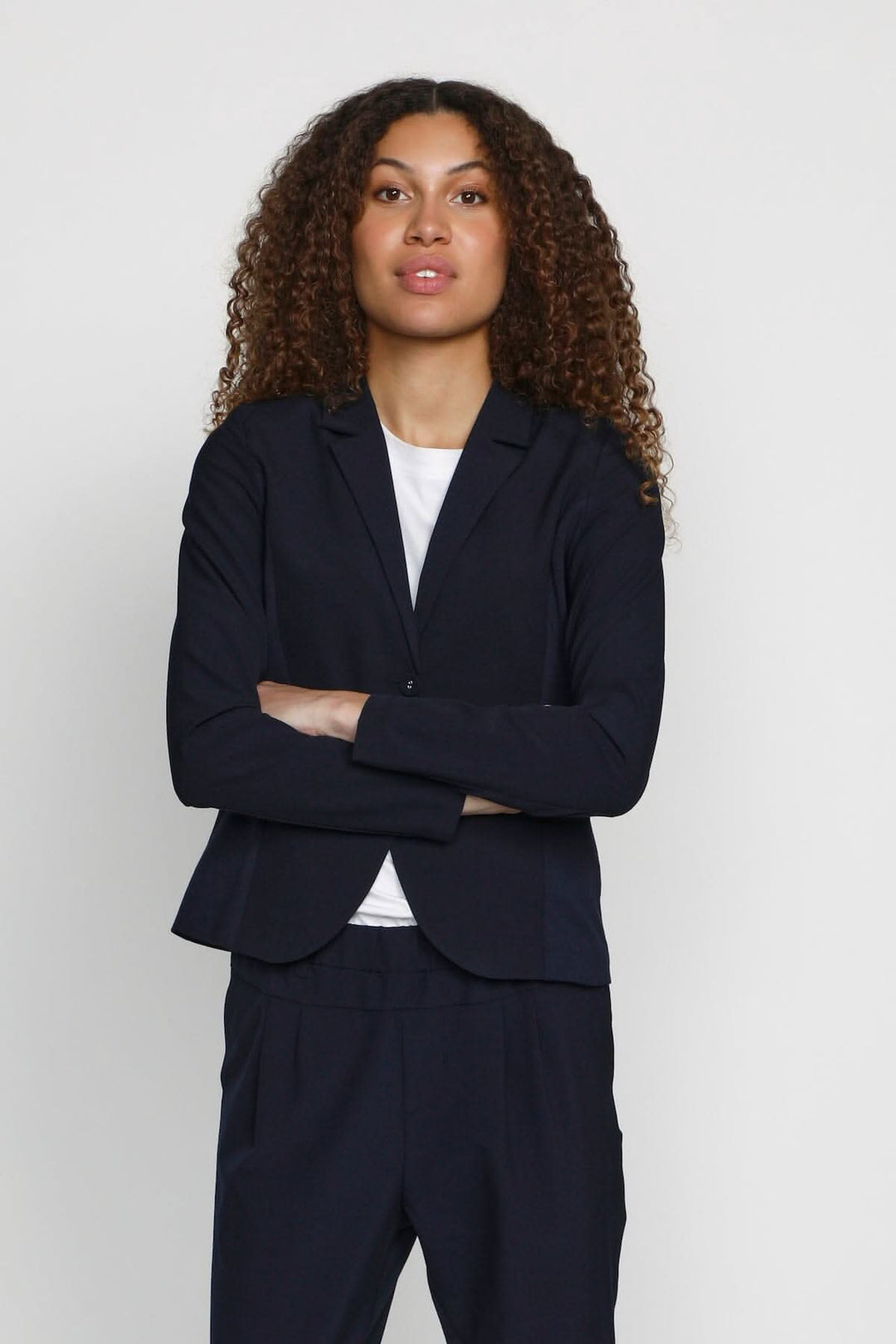 Femme portant un blazer Kajillian bleu marine, élégant et chic, idéal pour le bureau ou un événement.