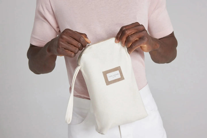 Homme tenant une pochette en coton blanc, accessoire de mode pratique et élégant, idéal pour le rangement.