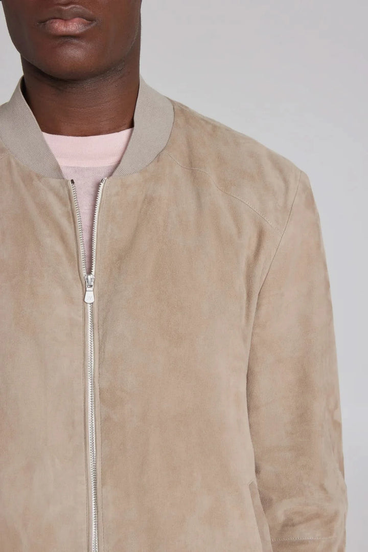 Homme portant un bomber ultraléger en daim beige avec fermeture éclair et col, style contemporain.