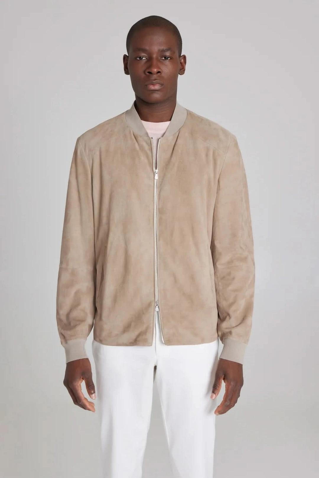 Modèle homme portant un bomber ultraléger en daim beige, style moderne et élégant.