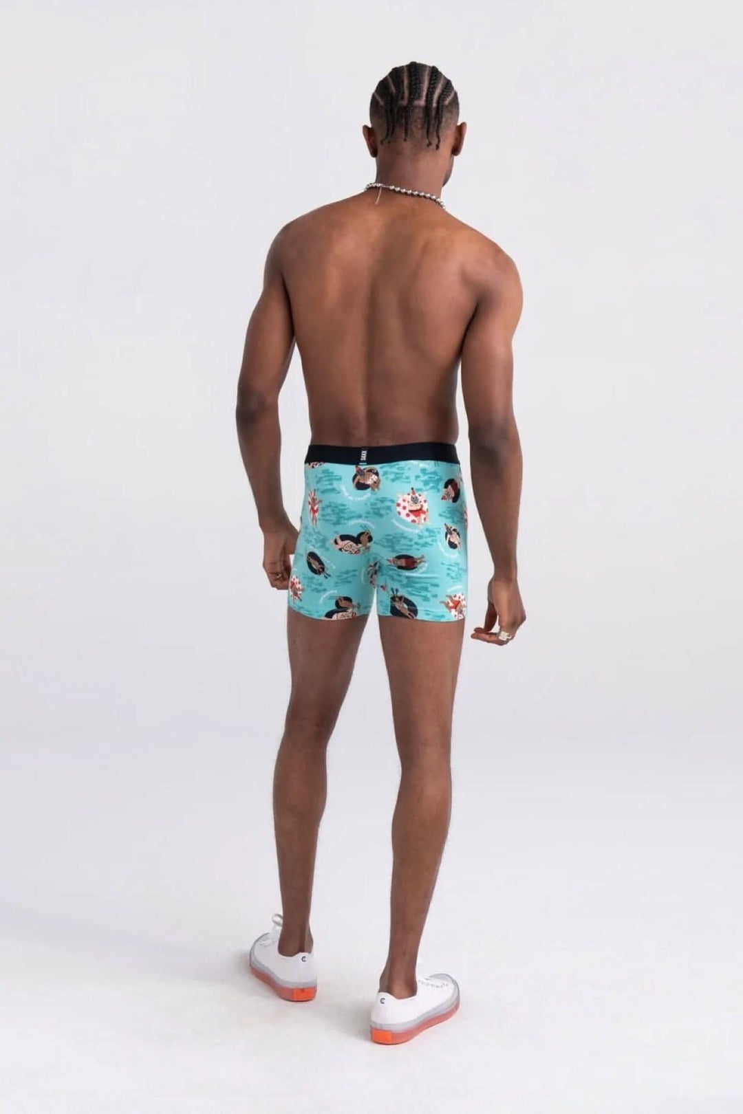 Homme portant des boxers colorés avec un motif animé, vu de dos, prêt à se détendre.