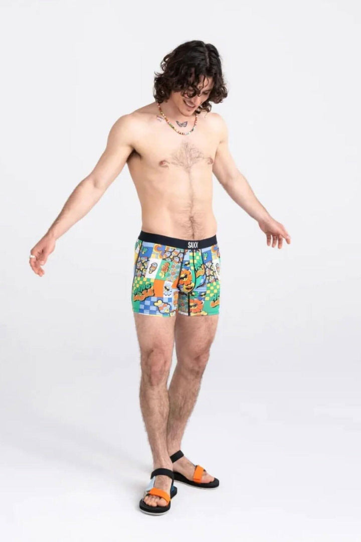 Homme portant un boxer coloré avec un motif ludique, parfait pour un style décontracté et confortable.