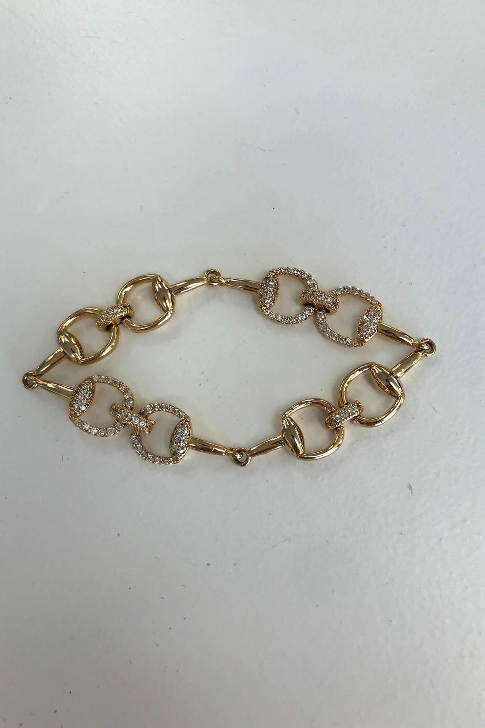 Bracelet doré avec breloques carrées et brillants incrustés, élégant pour toutes occasions.