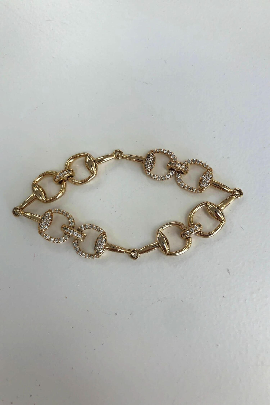 Bracelet doré avec breloques carrées et brillants incrustés, élégant pour toutes occasions.