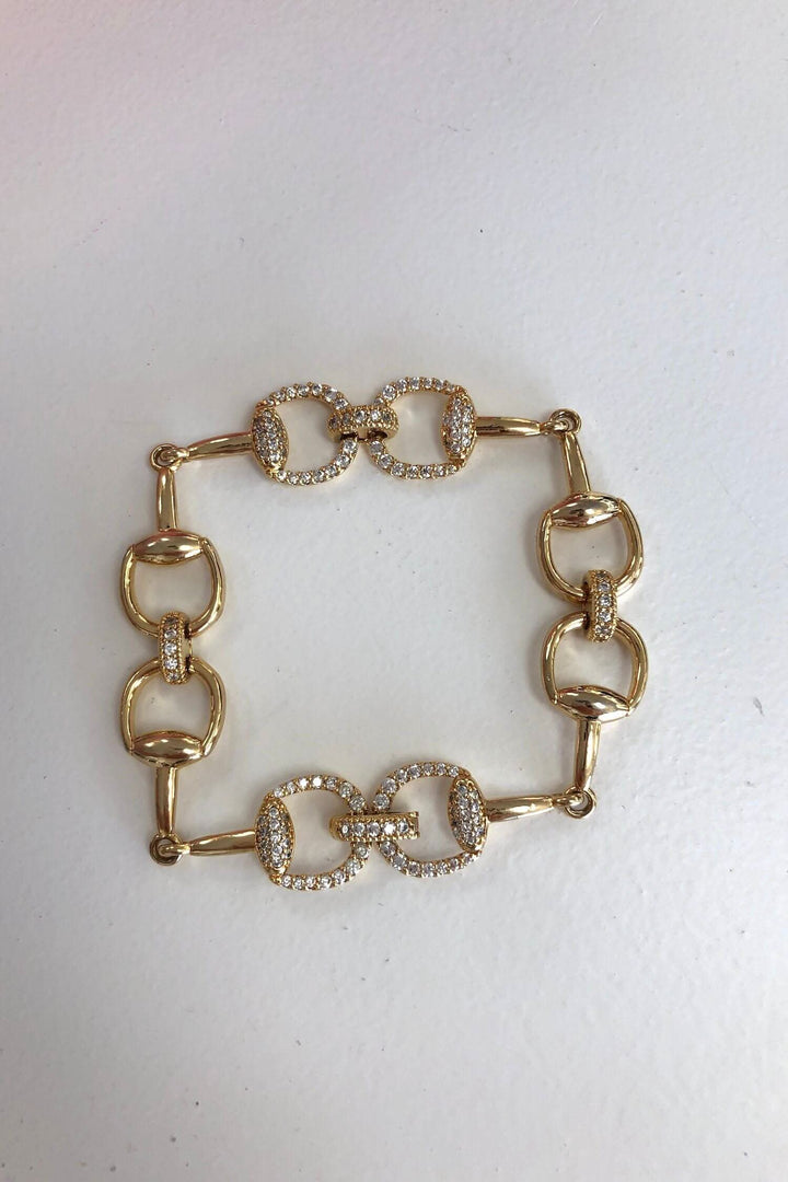 Bracelet doré élégant avec breloques carrées et brillants, idéal pour accessoiriser votre tenue.
