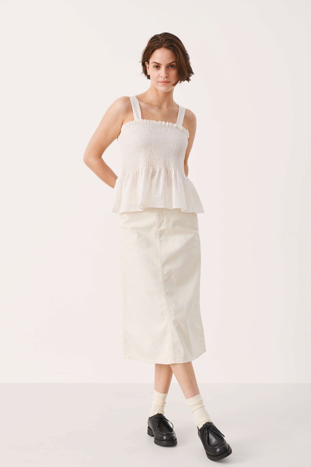Camisole Stevie blanche à bretelles larges, partie supérieure en nid d'abeille et bas fluide en volant.