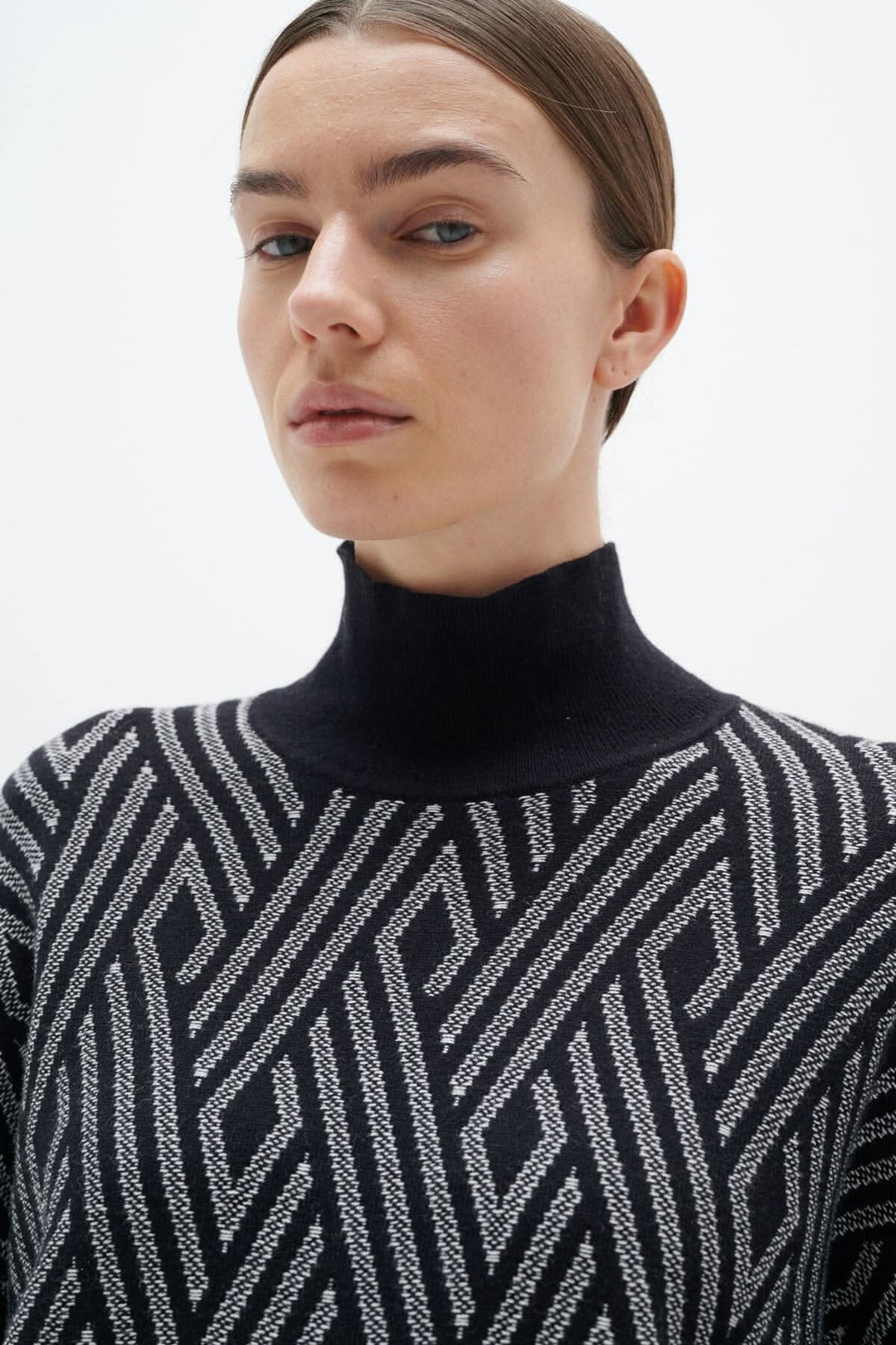 Chandail Gittel en noir et blanc avec col montant, ample en bas et ajusté en haut, parfait pour un style poncho.