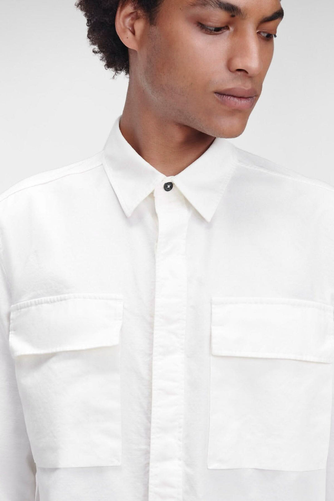 Chemise Batavia blanche à manches longues avec poches poitrine et fermeture dissimulée.
