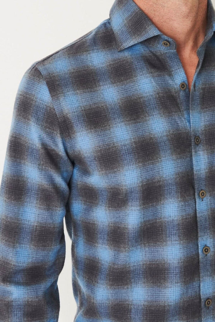 Chemise en flanelle à carreaux bleus et noirs, à manches longues, conçue pour un ajustement confortable.