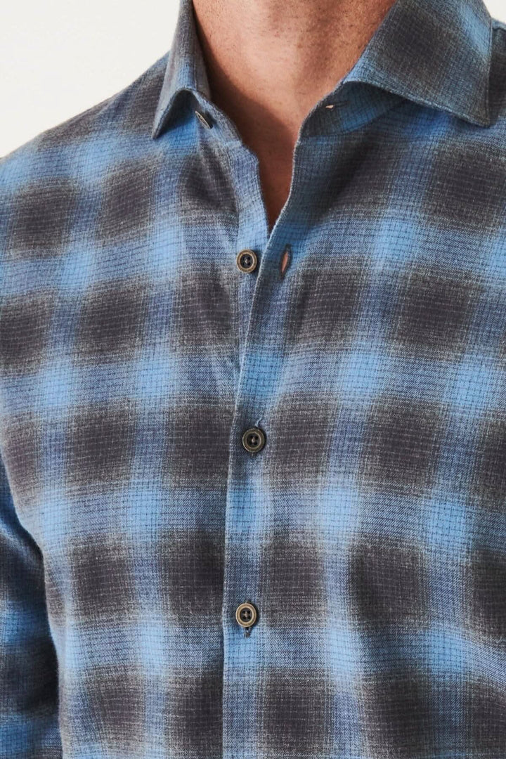 Chemise en flanelle à carreaux bleus et noirs, conçue pour un ajustement confortable et classique.
