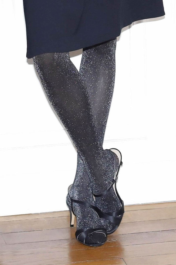 Collant semi-opaque 30D noir avec paillettes argentées, porté avec des chaussures à talons, idéal pour les fêtes.