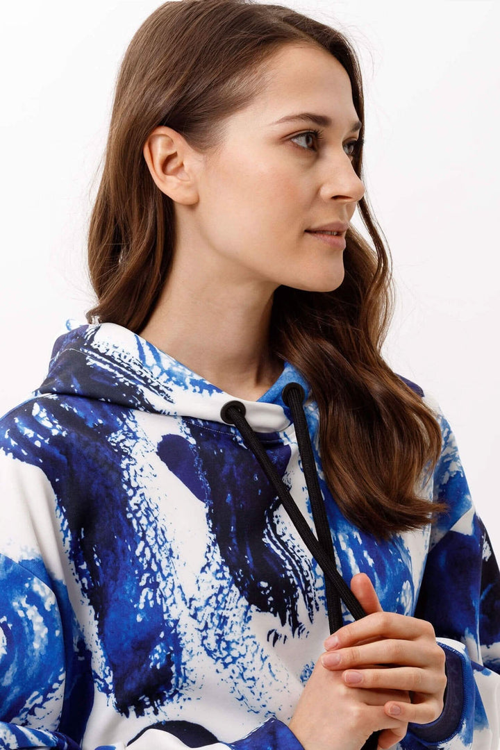 Femme portant un sweat-shirt Fayne BRAX LAB avec un design coloré, idéal pour un style décontracté et confortable.