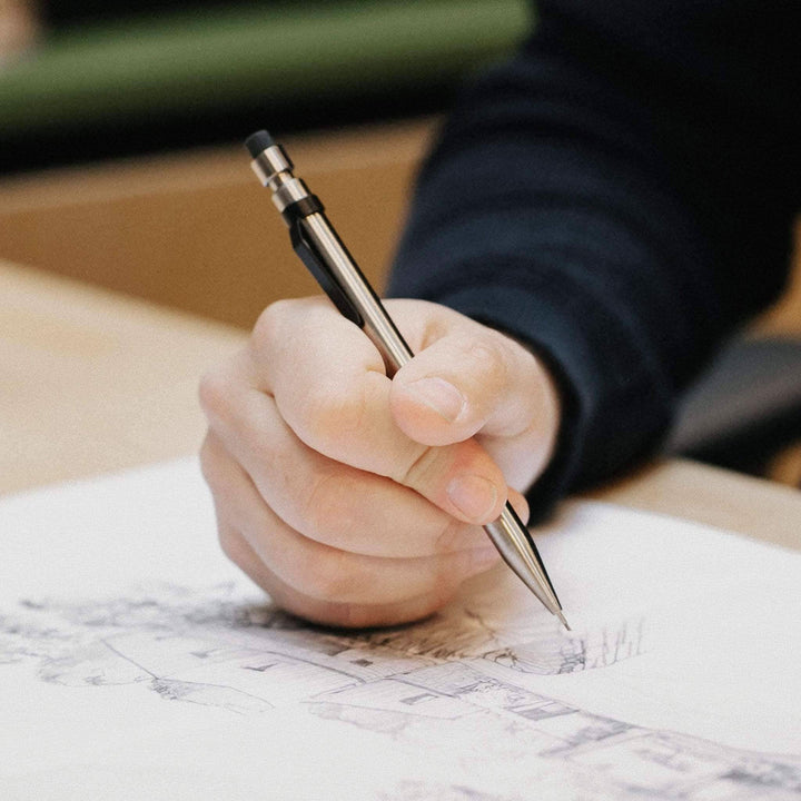 Main hand using a Modern Fuel crayon to sketch a drawing on paper.