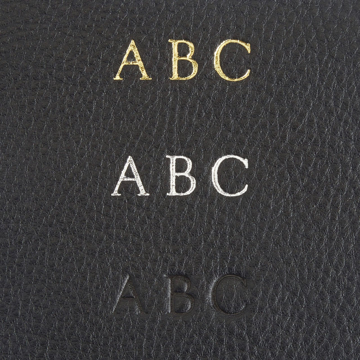 Monogrammed letters ABC in gold, silver, and black on textured leather background.
