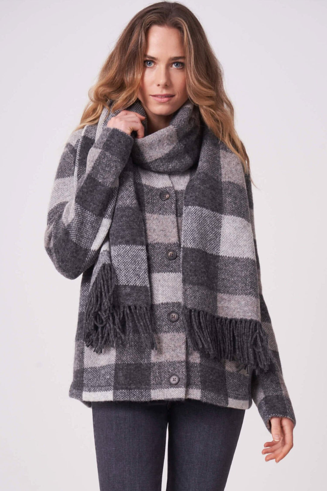 Foulard à carreaux gris et beige avec franges, porté avec une veste, style élégant et confortable.