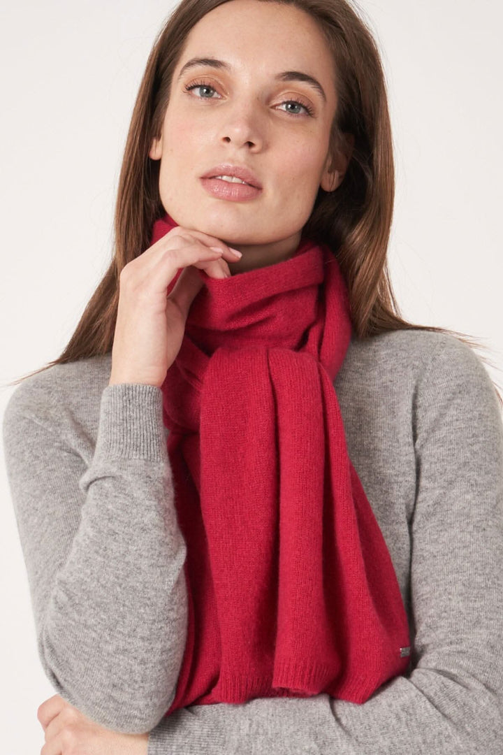 Foulard droit en cachemire rouge porté par une femme, offrant douceur et élégance.