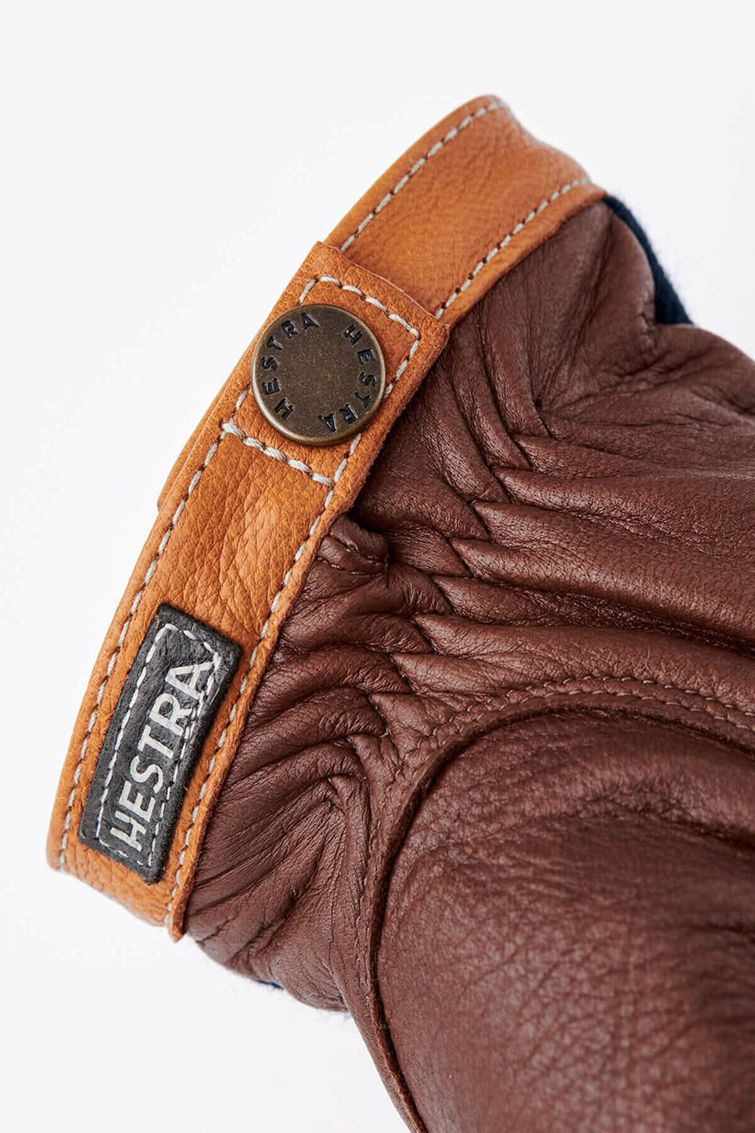 Gant en cuir marron avec une manchette en cuir tan et logo Hestra visible.
