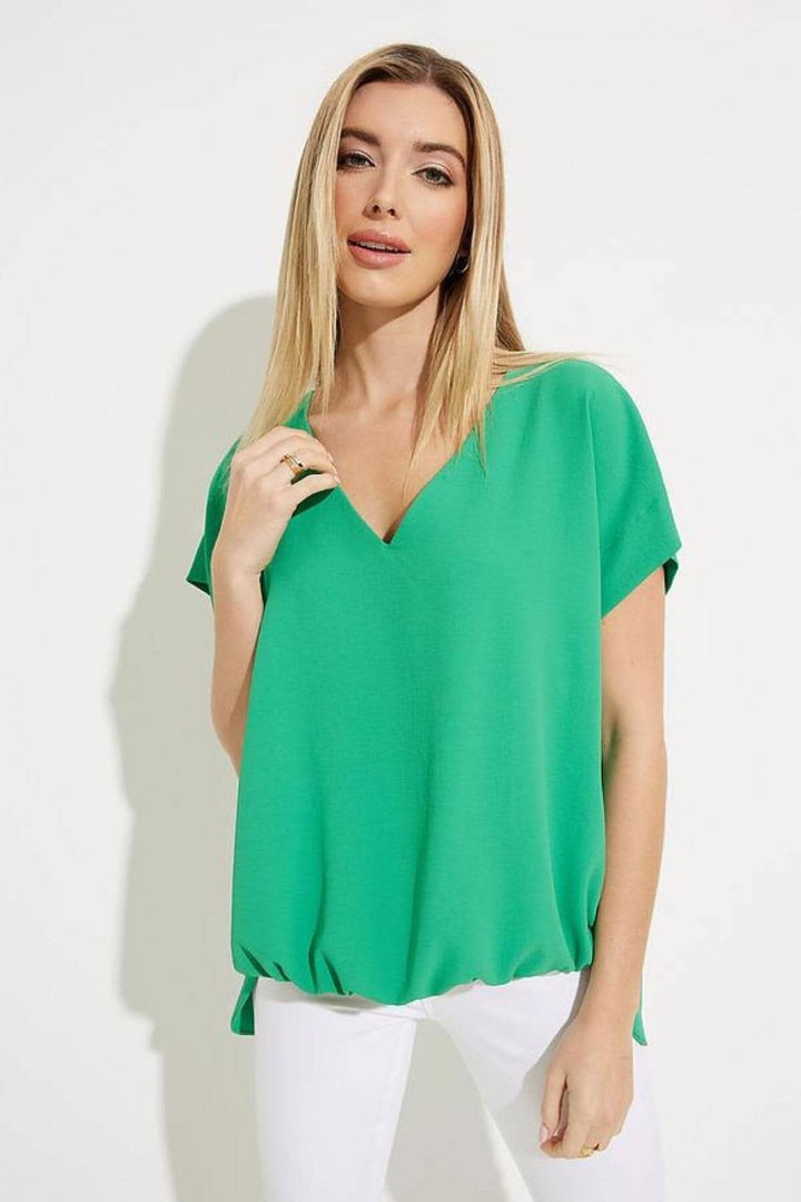 Haut asymétrique vert encolure en V, manches tombantes et ourlet froncé, style décontracté.