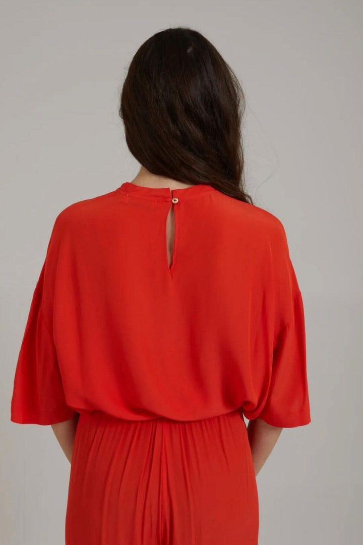 Haut rouge à manches midi avec ouverture à boutons dans le cou, vue de dos, coupe ample.