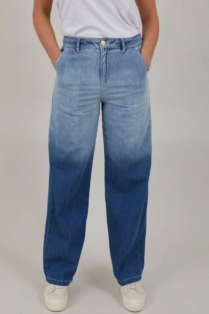 Jean à jambes larges dégradé bleu avec poches, taille haute et coupe Petra, porté avec un t-shirt.